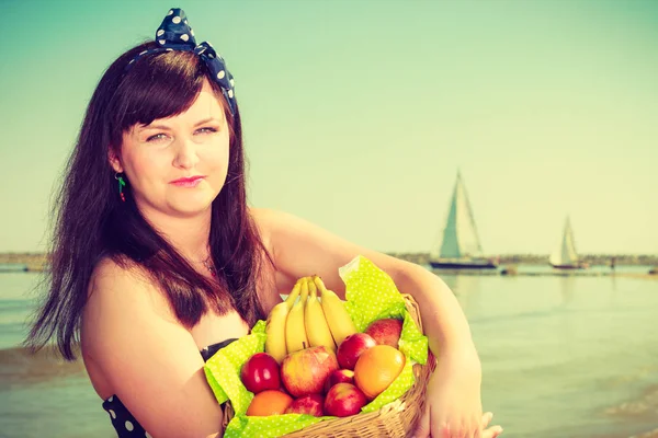 Mujer sosteniendo cesta de picnic con frutas — Foto de Stock