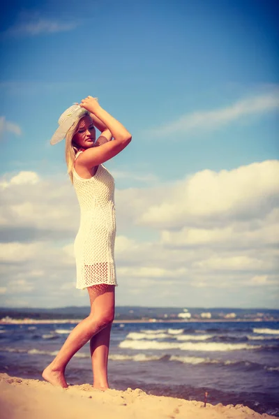 Blond kvinne i kjole, går på stranda – stockfoto