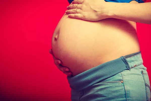 Donna adulta mostrando la sua pancia incinta — Foto Stock