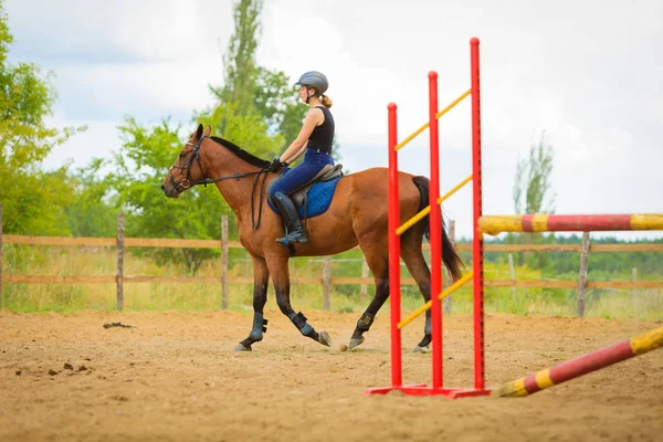 Jockey young girl doing horse jumping through hurdle — Stock Photo, Image