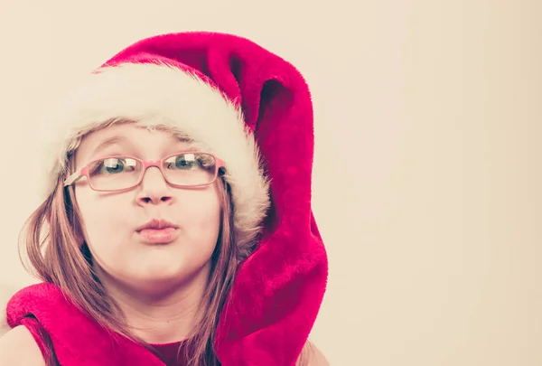바보 같은 얼굴을 만드는 산타 모자에 소녀 — 스톡 사진