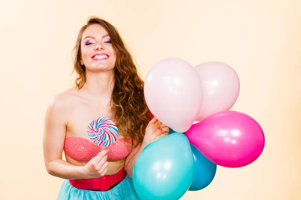 Woman holds lollipop candy and balloons — Stock Photo, Image