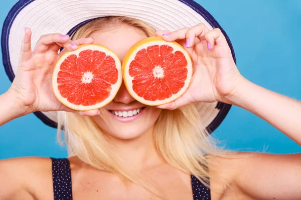 Mulher segurando fruta de toranja vermelha como óculos — Fotografia de Stock