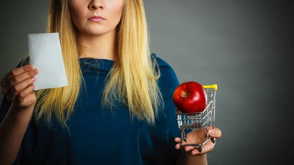 Femme inquiète tenant panier avec des fruits — Photo