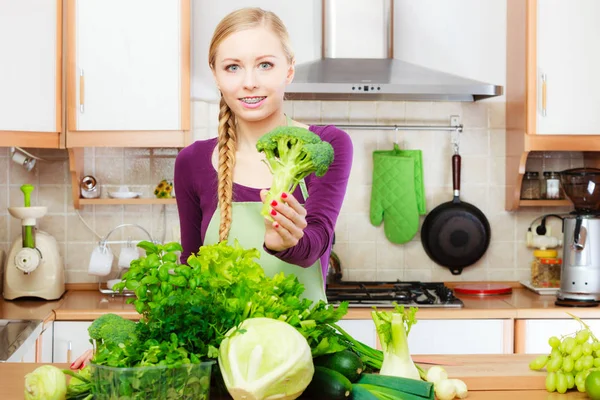 Femme dans la cuisine avec des légumes verts brocoli à la main — Photo