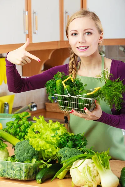 Femme dans la cuisine ayant des légumes tenant panier — Photo