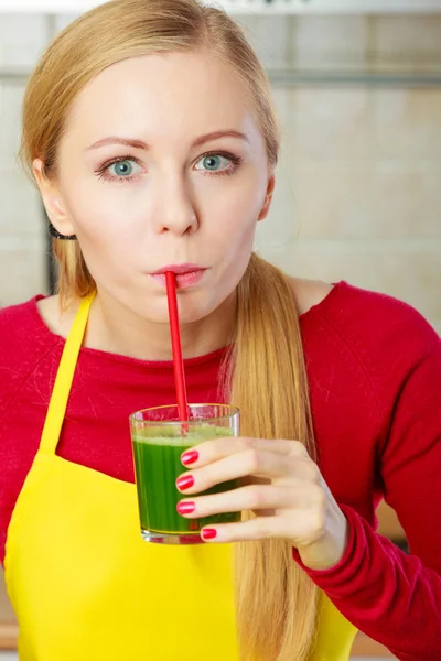 Woman in kitchen holding vegetable smoothie juice — Stock Photo, Image