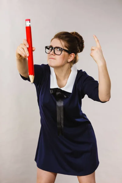 Mujer enojada sostiene lápiz grande en la mano — Foto de Stock