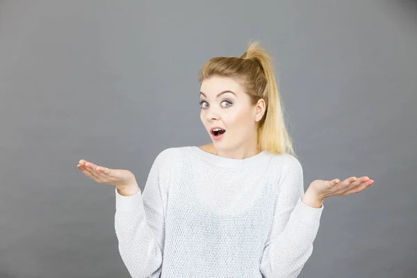 Verwirrte junge blonde Frau gestikuliert mit Händen — Stockfoto