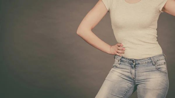 Женщина в узких джинсах и белой футболке — стоковое фото