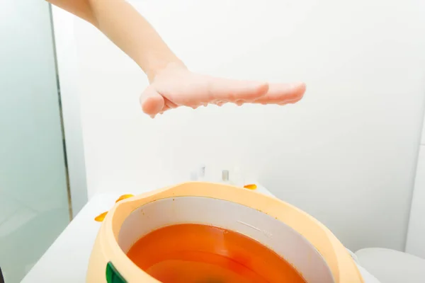 Woman getting paraffin hand treatment at beautician — Stock Photo, Image