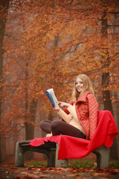 Chica rubia leyendo libro en el paisaje de otoño — Foto de Stock