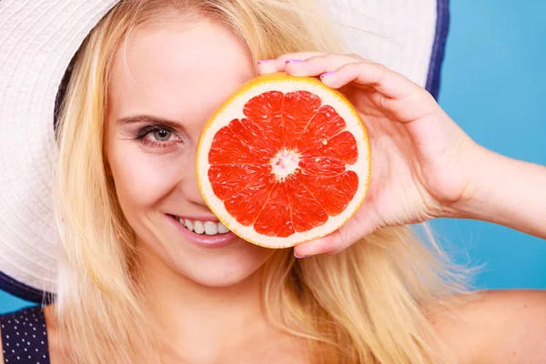 Vrouw met rode grapefruit fruit wearin zon hoed — Stockfoto