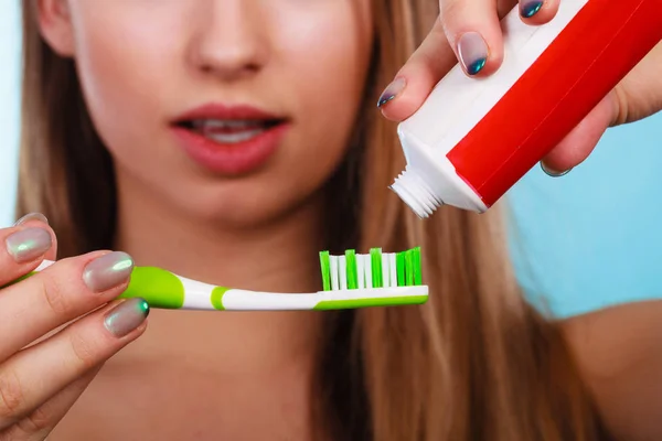 Femme appliquant du dentifrice sur sa brosse à dents — Photo