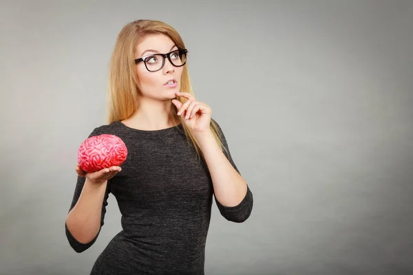 Woman thinking and holding fake brain — Stock Photo, Image