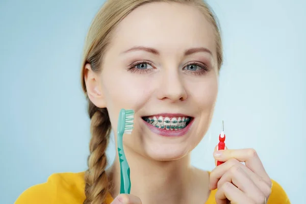 Menina com aparelho de dentes usando escova interdental e tradicional — Fotografia de Stock