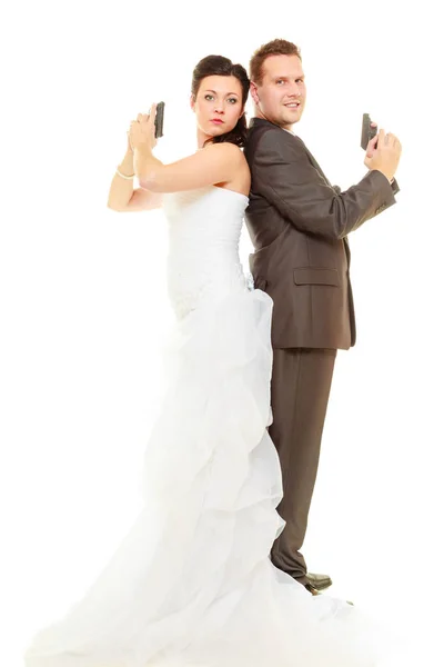 Ženich a nevěsta ve svatební oblečení drží zbraně — Stock fotografie