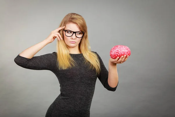 Mujer pensando y sosteniendo cerebro falso — Foto de Stock