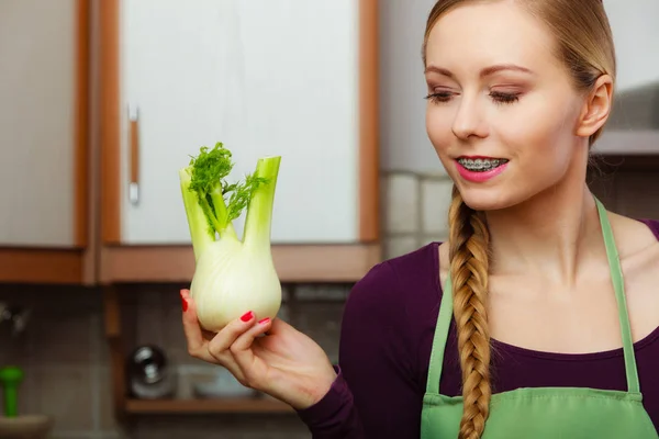 Frau in Küche hält rohes Fenchelzwiebelgemüse — Stockfoto