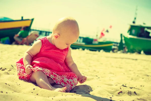 Pequeno bebê sentado e brincando na praia — Fotografia de Stock