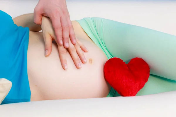 Пара, що очікує дитину, їх руки торкаються вагітного живота — стокове фото