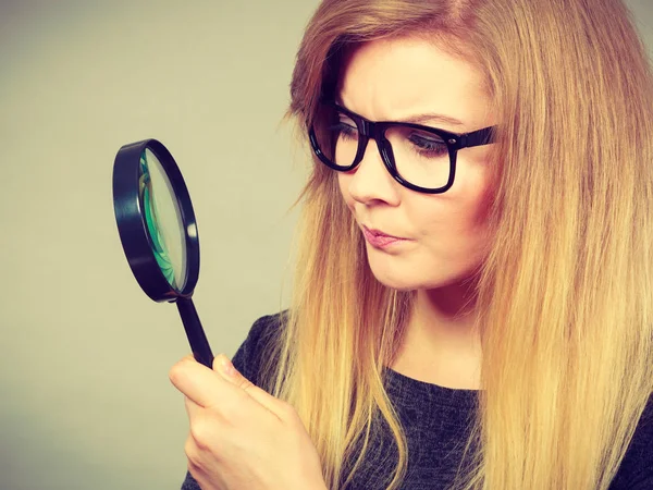 Woman holding magnifying glass investigating — Stock Photo, Image