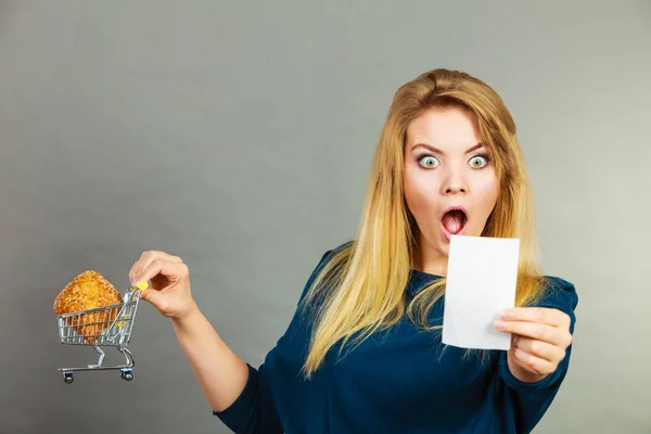 Mujer sorprendida sosteniendo cesta de la compra con pan — Foto de Stock