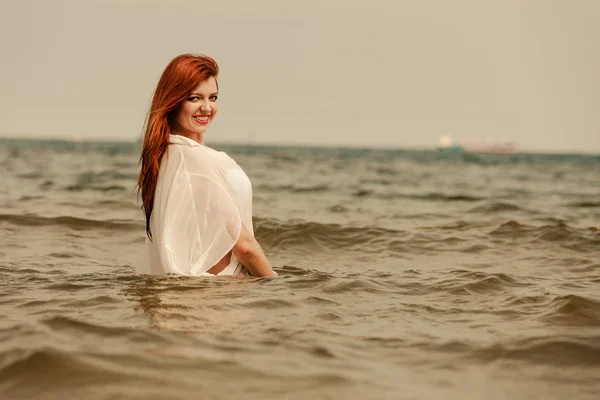 Roodharige vrouw spelen in water gedurende de zomermaanden — Stockfoto