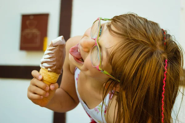 幼児女の子で眼鏡をかけて食べるアイスクリーム — ストック写真
