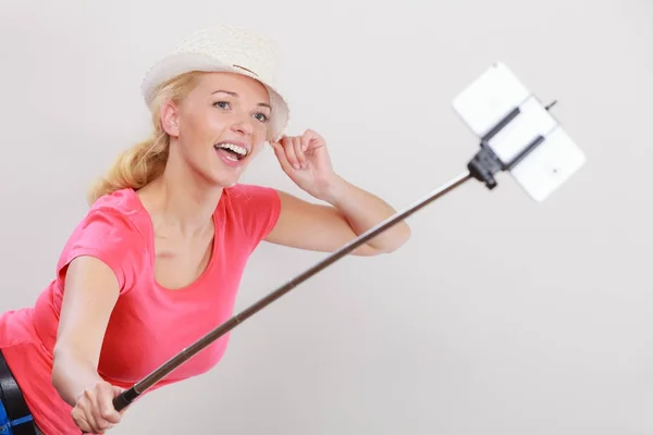 Donna che si fotografa con il telefono su bastone — Foto Stock