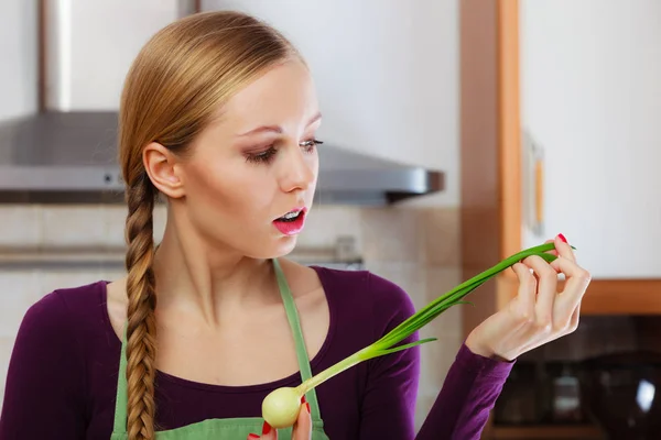 Mulher na cozinha detém cebolinha fresca verde — Fotografia de Stock