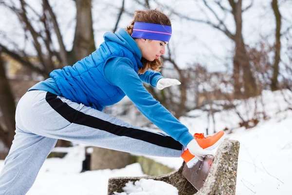 Mulher vestindo sportswear exercitando fora durante o inverno — Fotografia de Stock