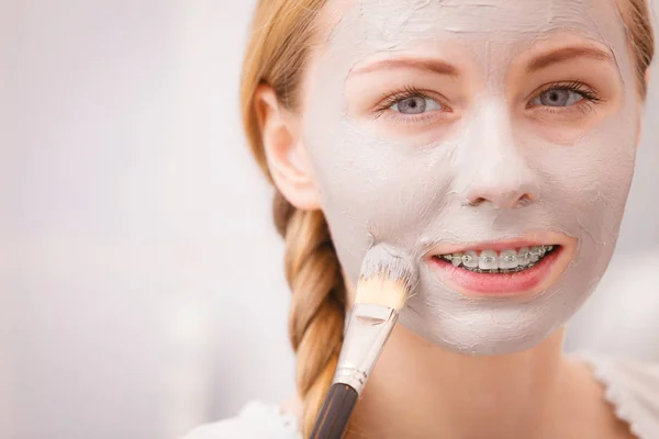 Gelukkig jonge vrouw modder masker aanbrengen op gezicht — Stockfoto