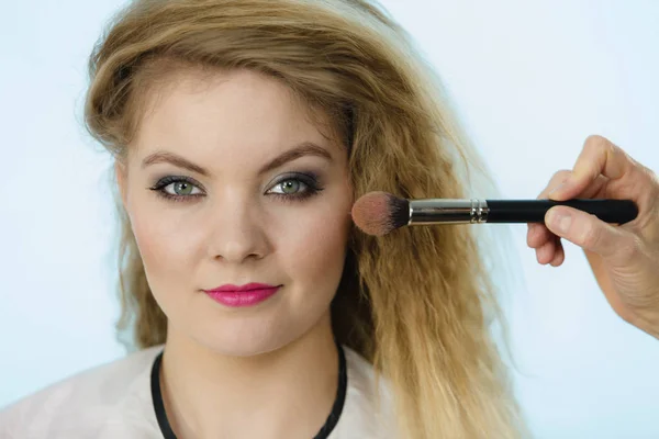 Makeupartist ansöker med borste rouge på kvinnliga check — Stockfoto