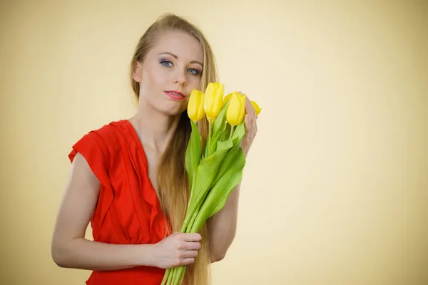 Mooie vrouw met gele tulpen bos — Stockfoto