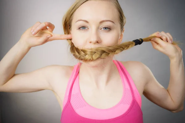 Frau bedeckt ihren Mund mit blondem Zopf — Stockfoto