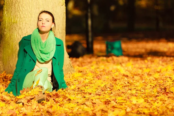 Vrouw zitten op herfst bladeren — Stockfoto