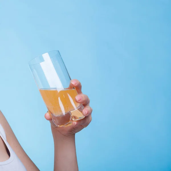 Mujer sosteniendo vaso de naranja con sabor a bebida —  Fotos de Stock