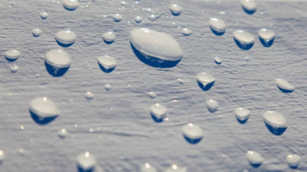 Vattendroppar på ljus blå träskiva — Stockfoto