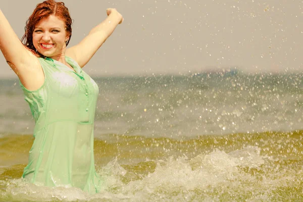 Redhead woman playing in water during summertime — Stock Photo, Image