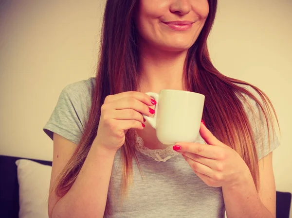 Mujer sonriente sosteniendo una taza de té — Foto de Stock