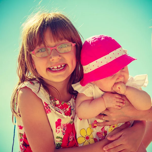 Kleinkind hält seine Schwester an sonnigem Tag — Stockfoto