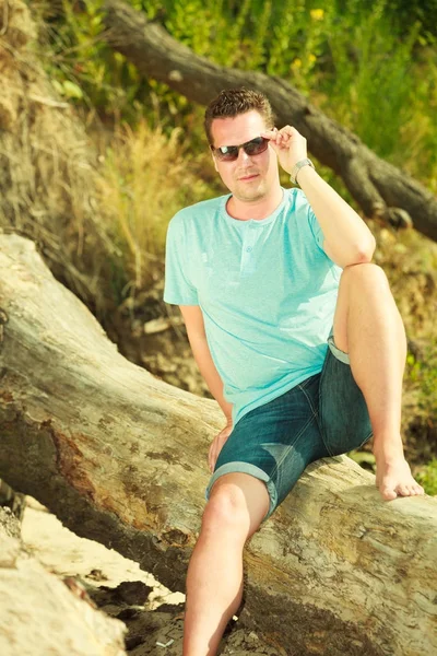 Yakışıklı adam yaz aylarında sahilde rahatlatıcı. — Stok fotoğraf