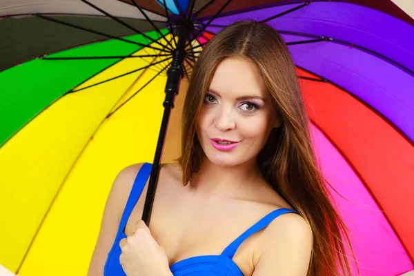 Mujer de pie bajo el colorido paraguas del arco iris — Foto de Stock