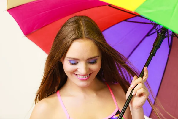 Frau steht unter buntem Regenschirm — Stockfoto