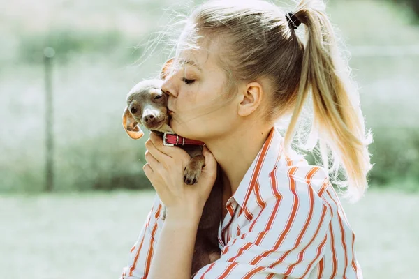 Kvinna leker med lilla hunden utanför — Stockfoto