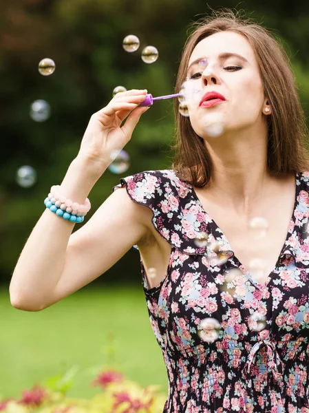 Frau pustet Seifenblasen, hat Spaß — Stockfoto