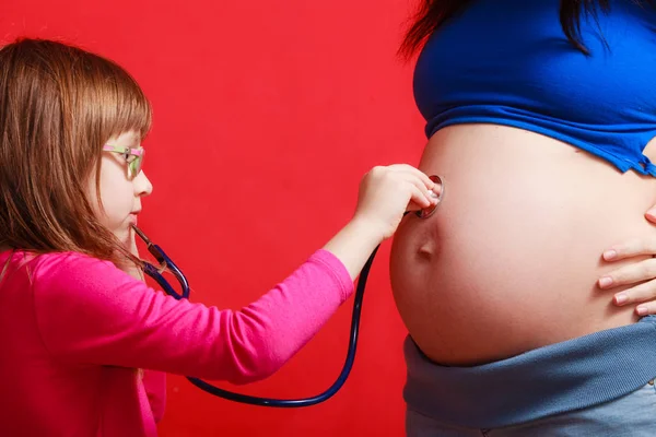 Kızı hamile anne stetoskop kullanarak — Stok fotoğraf