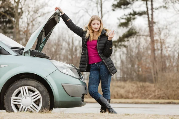 Blonde woman and broken down car on road — Stock Photo, Image