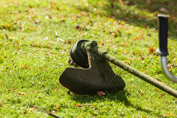 在绿色草地上的割草机 brushcutter — 图库照片